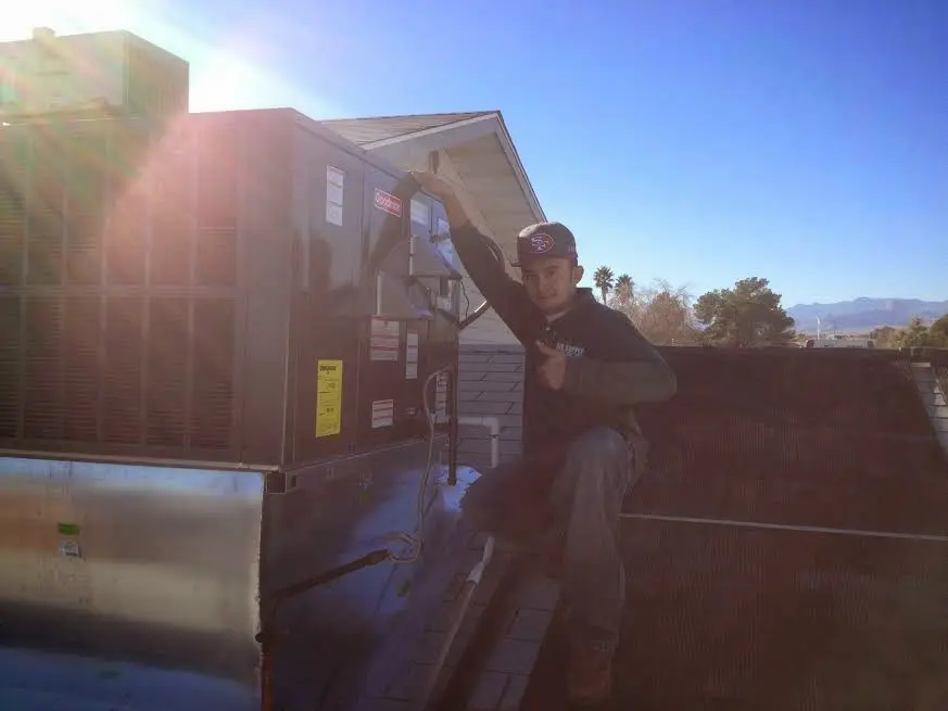 HVAC technician performing AC Tune-Up on a rooftop unit in Omaha